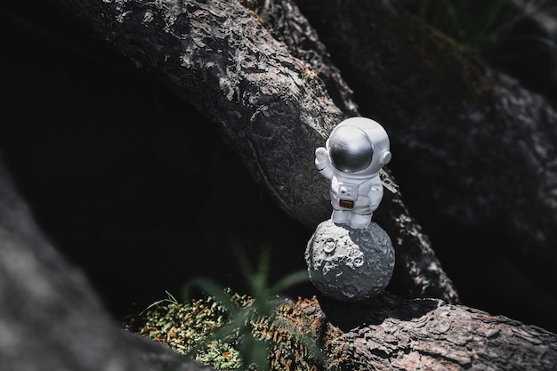 astronaut figurine stands among the stones