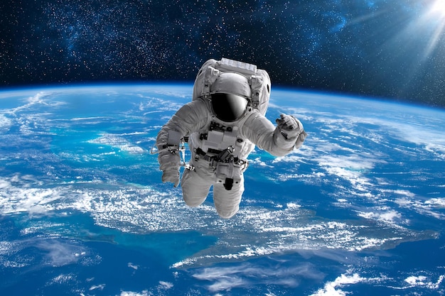 Astronaut in outer open space over the planet Earth.Stars provide the background.erforming a space above planet Earth.Sunrise,sunset.Our home. ISS.Elements of this Image Furnished by NASA.