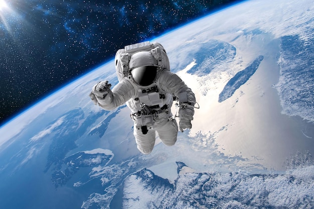 Astronaut in outer open space over the planet Earth.Stars provide the background.erforming a space above planet Earth.Sunrise,sunset.Our home. ISS.Elements of this Image Furnished by NASA.