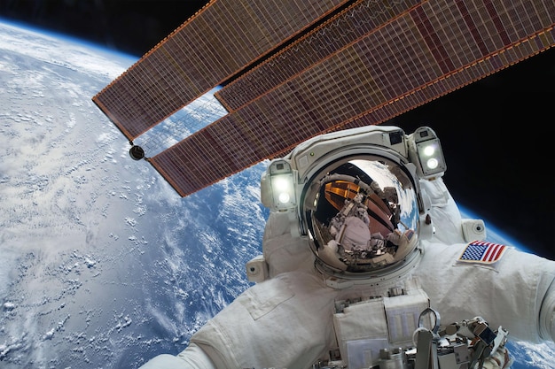 Astronaut in outer space against the backdrop of the planet earth. Elements of this image furnished by NASA.