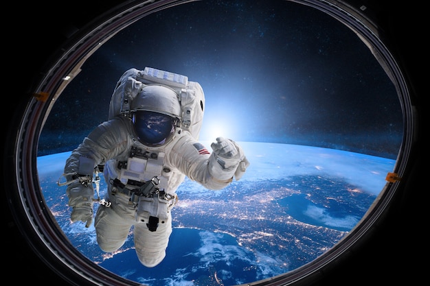 Astronaut in outer space from porthole on of the Earth