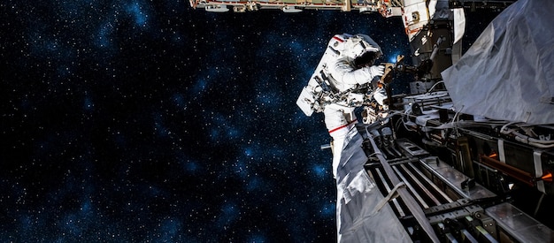 Astronaut-ruimtevaarder doet ruimtewandeling terwijl hij voor het ruimtestation werkt
