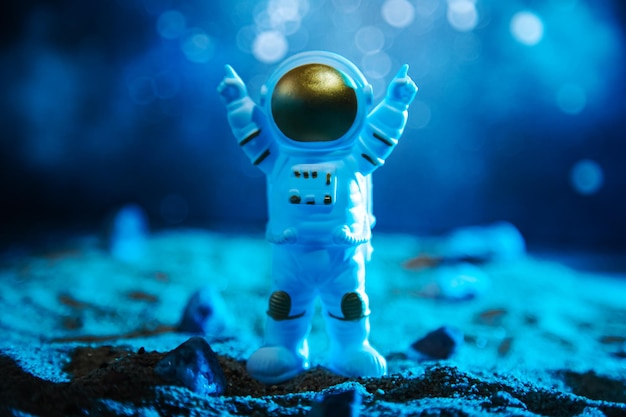 宇宙服を着た宇宙飛行士が別の惑星への歓迎のサインで手を上げた未来の宇宙背景コンセプト