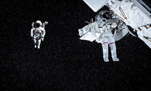 Gli astronauti astronauti fanno una passeggiata nello spazio mentre lavorano per la stazione spaziale