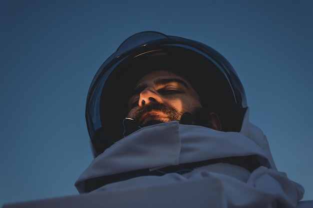 Astronaut staat tegen een heldere hemel.