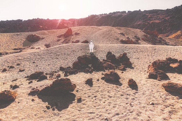 Foto astronauta in piedi sulla sabbia durante una giornata di sole