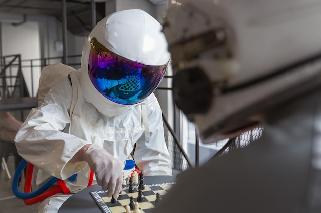 Astronauts playing chess in space suits in capsule hotel