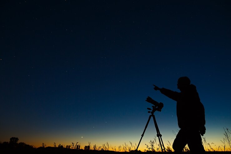 Photo the astronomer photographs the night starry sky on a digital camera using a tripod.