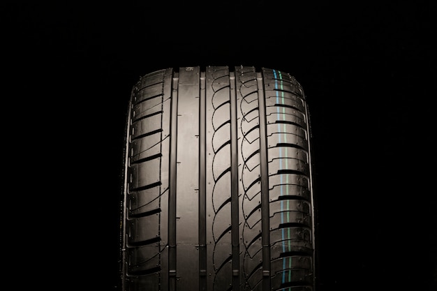 Asymmetric summer tire. front view, close-up on a black space