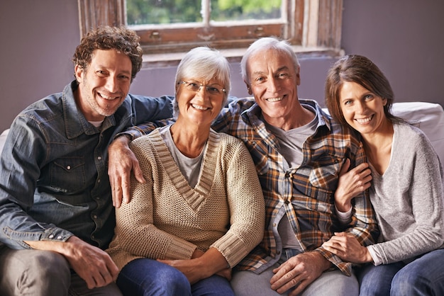 사진 inlaws 집에서 성인 자녀와 함께 앉아 있는 행복한 성숙한 부모의 초상화