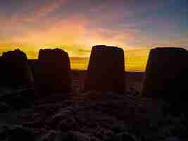 Photo atardecer en la playa entre las almenas del castillo de arena