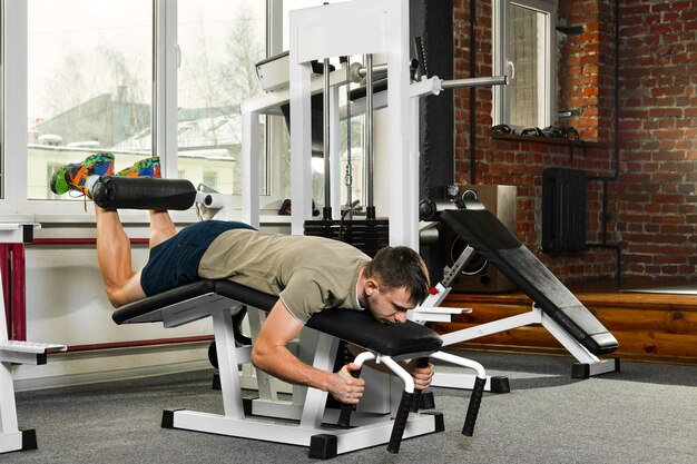 Atheletic man swing the abdominal muscles in gym