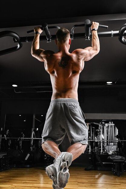 The athlete does a pull-up on the horizontal bar.