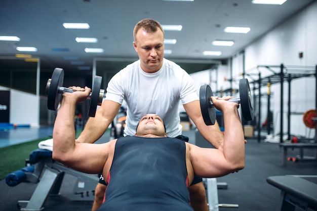 Athlete doing exercise under instructor control