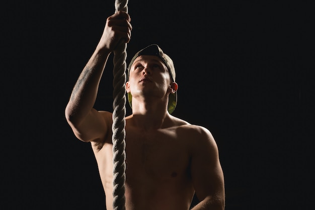 Athlete doing Fitness Rope Climb Exercise In Fitness Gym Workout