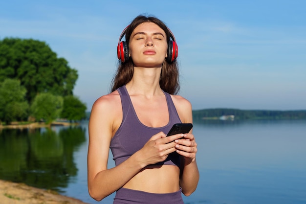 An athlete enjoys music from headphones during a workout outside