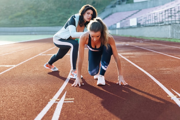 Esercizi di atleti con personal trainer in piedi all'inizio dello stadio e poi correre in avanti