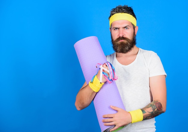 Athlete guide stay in shape. Man bearded athlete hold fitness mat and tape measure. Athlete professional coach motivated for training. Old school aerobics concept. Athlete wear bandages for sweat.
