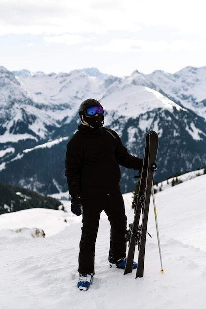 the athlete holds skis portrait of a male skier at the top of the piste ski resort extreme sport