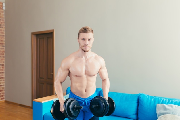 athlete at home doing fitness uses dumbbells