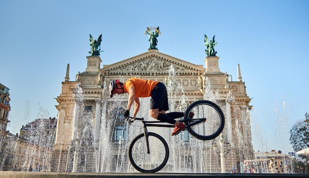 Athlete is cycling downtown near fountain