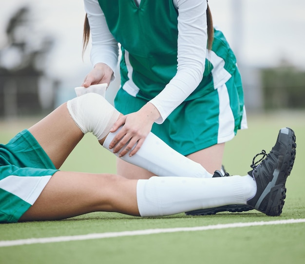 Photo athlete knee injury and help on field sports and accident in sportswear person emergency and first aid for joint pain bruise and inflammation to bandage broken by fall and suffering in game