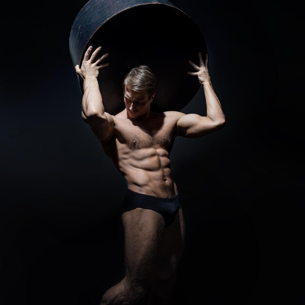 Foto un atleta come un atlantideo tiene il peso sulle spalle un atleta muscoloso il corpo di un antico