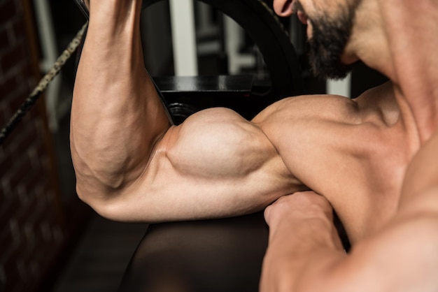 Photo athlete man doing heavy weight exercise for biceps