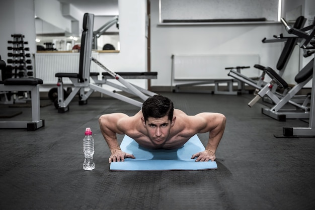 Athlete man doing push-ups in sport gym