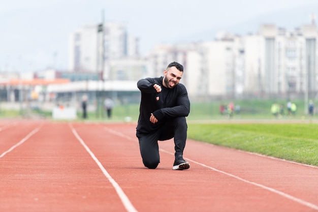 Спортсмен отдыхает после бега на улице, показывая большой палец вверх