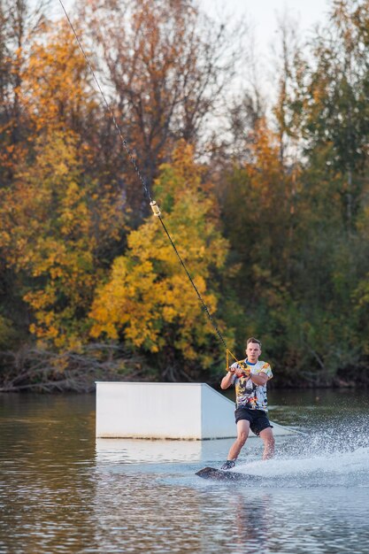 An athlete performs a trick on the water park at sunset wakeboard rider