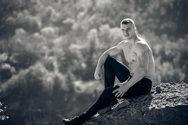 Athlete portrait. Posing outdoor. Photo in a quarry. Black and white photo. Nature landscape.