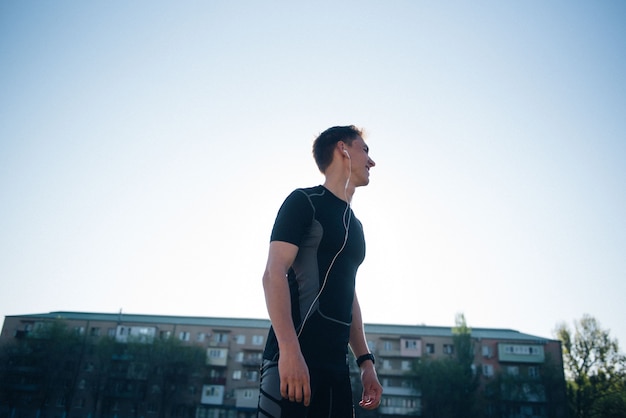 The athlete puts on headphones before jogging