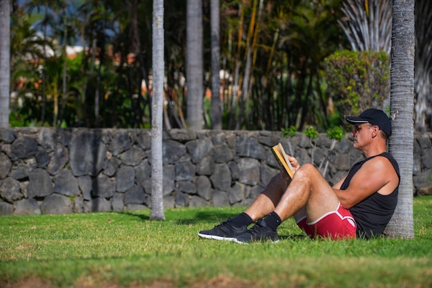 写真 公園で本を読んでいる運動選手