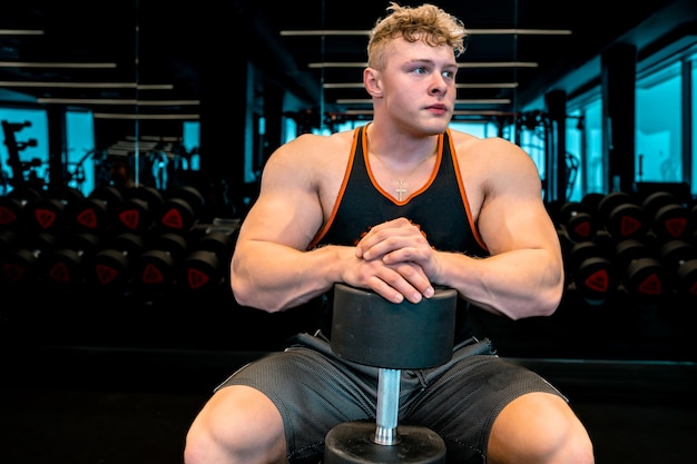 Athlete resting in the gym between barbell exercises