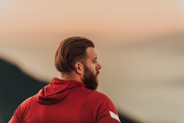 An athlete rests on top of a mountain after exhausting running training.