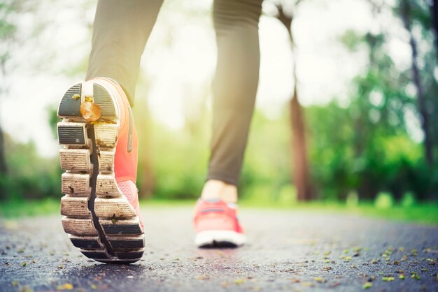 Piedi del corridore dell'atleta che corrono sul primo piano della strada sulla scarpa. scarpe da jogger con spazio libero indietro