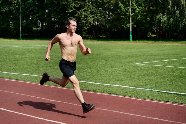 Photo athlete runner trains at the stadium