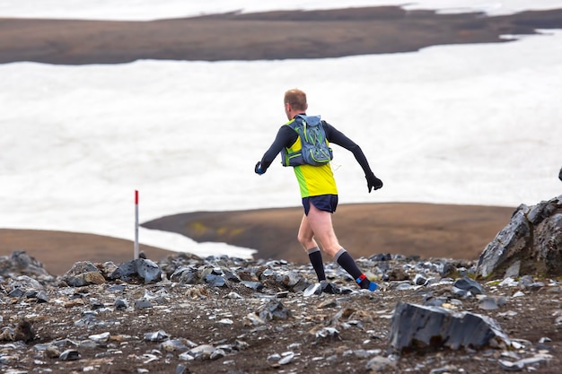 선수들이 Landmannalaugar의 눈 덮인 지형에서 산악 마라톤을 실행합니다.