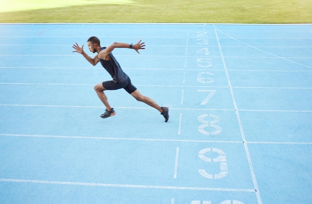 Foto atleta che corre in pista durante la pratica di allenamento competitiva corridore maschio attivo in forma atletica per tutta la lunghezza che sprint con velocità nel centro sportivo esercizio di salute cardio e resistenza durante l'allenamento