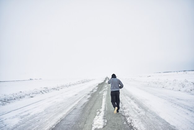 The athlete runs in the winter on the road