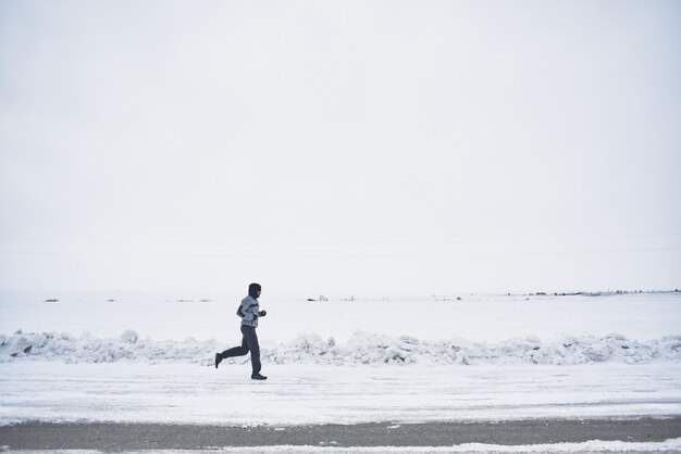 The athlete runs in the winter on the road