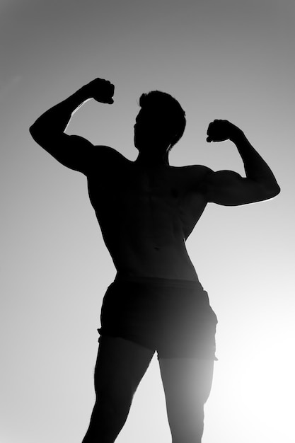 Photo athlete showing muscular body in dusk