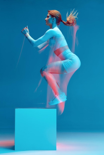 Foto atleta ragazza sportiva che salta al cubo allenamento intensivo della piattaforma per il movimento di lunga esposizione di resistenza