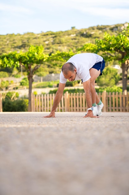 Photo athlete in the starting position of the race in the sunlight