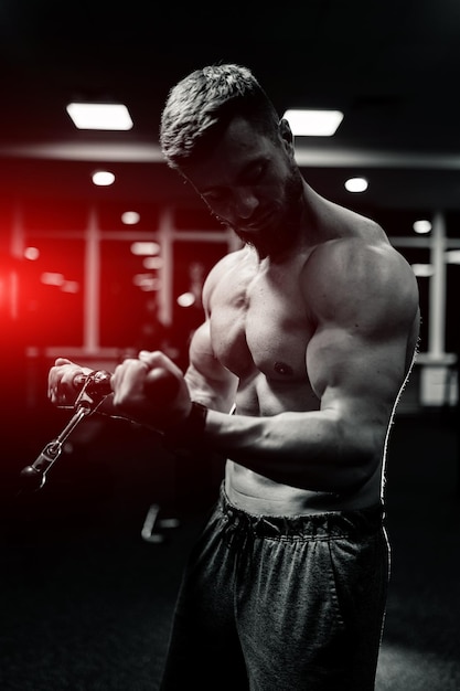 Athlete strong sporty bodybuilder. Handsome muscular man posing in the gym.