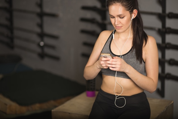 Спортсмен с помощью мобильного телефона фитнес-трекер для отслеживания прогресса в потере веса