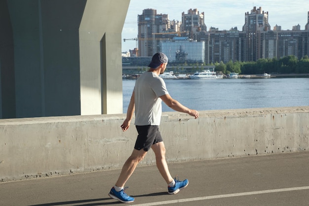 Athlete walks along the embankment after jogging