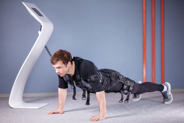 Athlete wearing ems suit doing plank