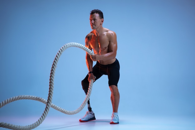 Athlete with disabilities or amputee isolated on blue studio background Professional male